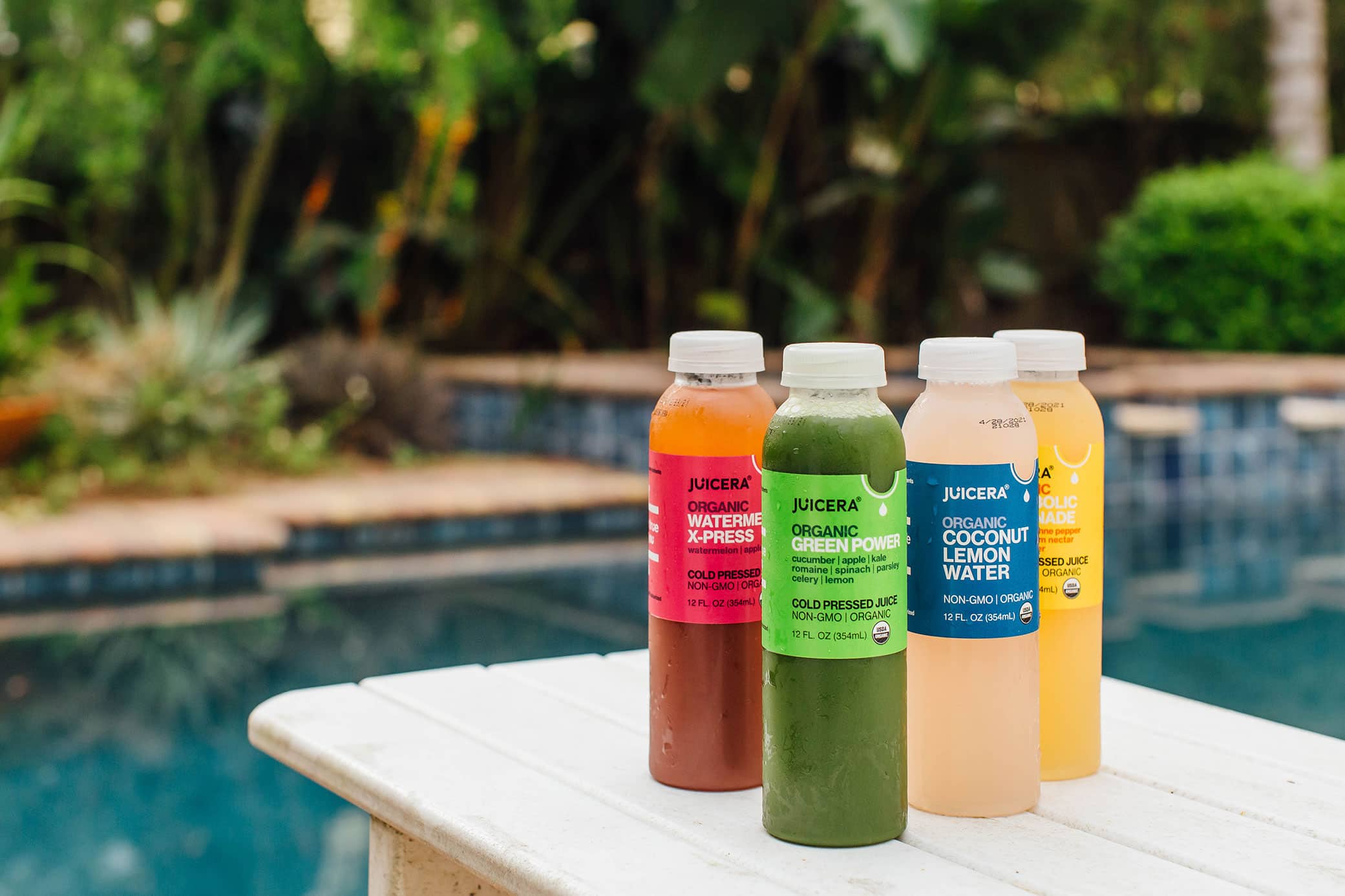 Juicera packaging design showcased poolside with different flavors displayed on a table.