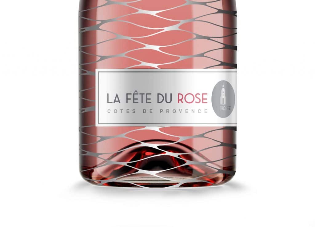 St. Tropez Rose wine bottle design close-up view showing label with St Tropez church steeple against wave-like silver mesh.