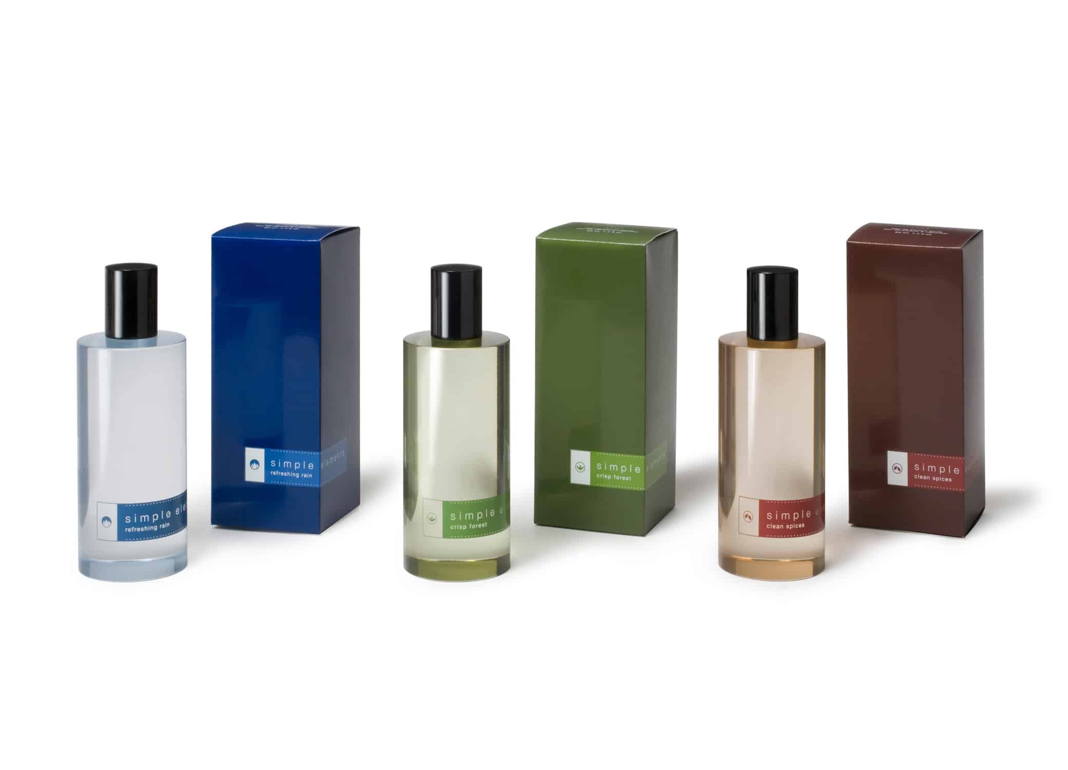 Avon Simple Elements fragrance line packaging design with transparent bottles and dark blue, green and red labels.