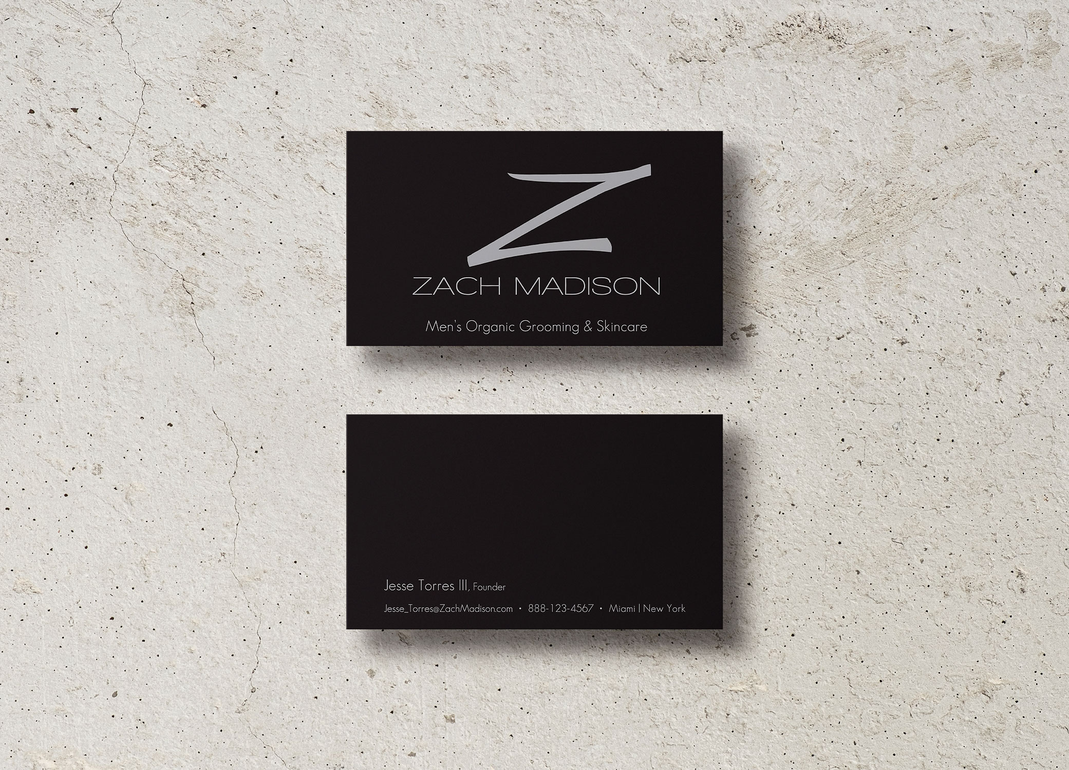 Zach Madison black business cards with metallic 'Z' showing front and back on top of granite backdrop.