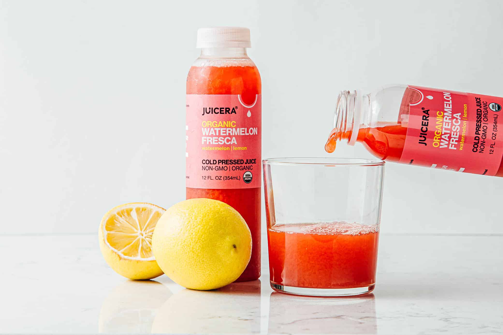 Juicera packaging design showcasing Watermelon Fresca flavor being poured into a glass with cut lemon near.