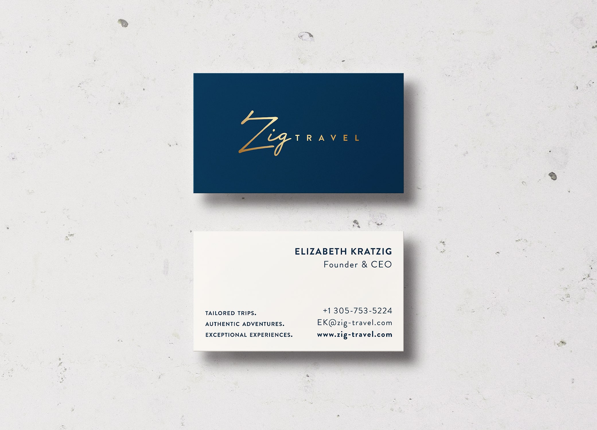 Zig Travel business cards in white and navy with luxe gold lettering arrayed in diagonal rows to show front and back.