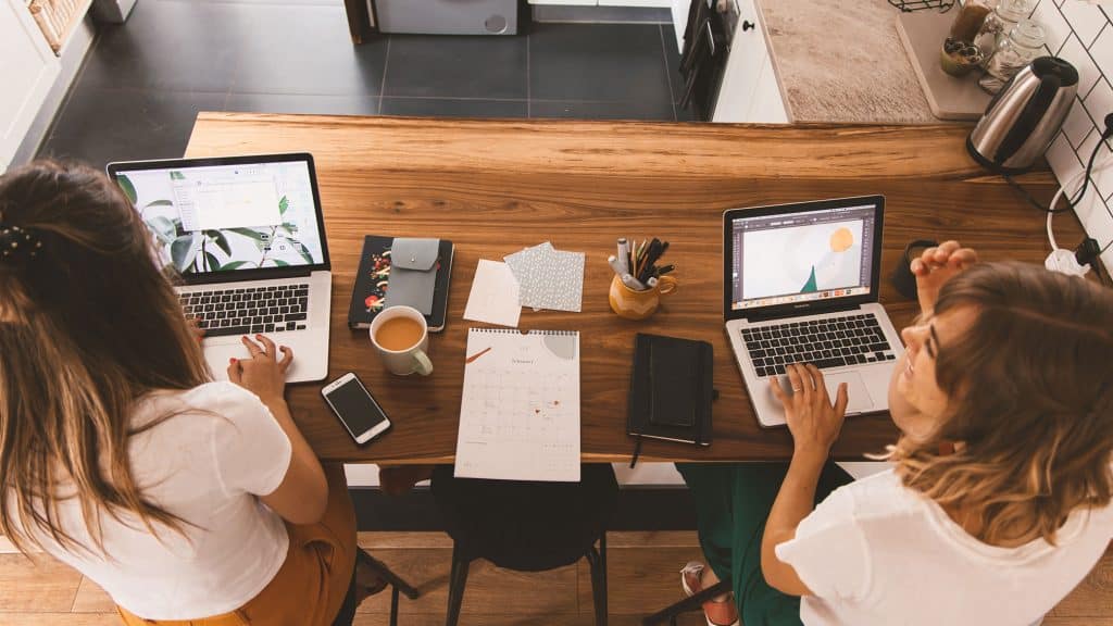 Women entrepreneur working together on laptops in an office setting.