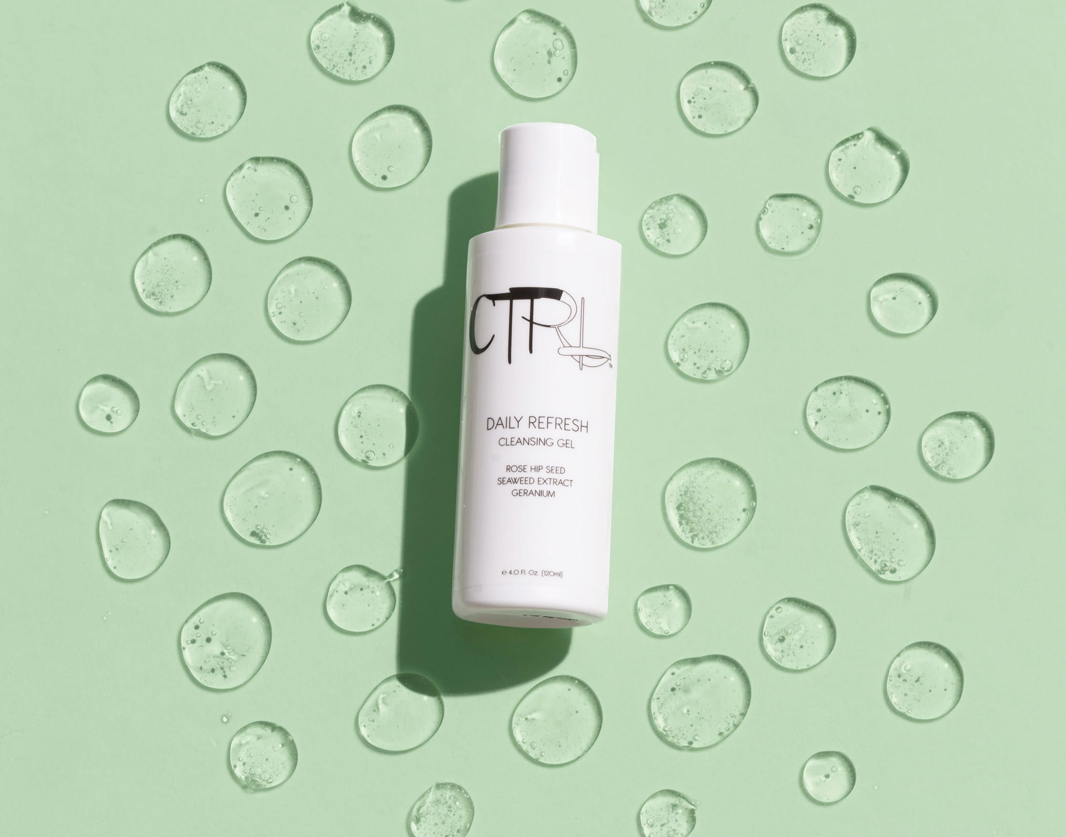 CTRL Cosmetics packaging design showcasing skincare product against light green backdrop with drops of liquid around the bottle.