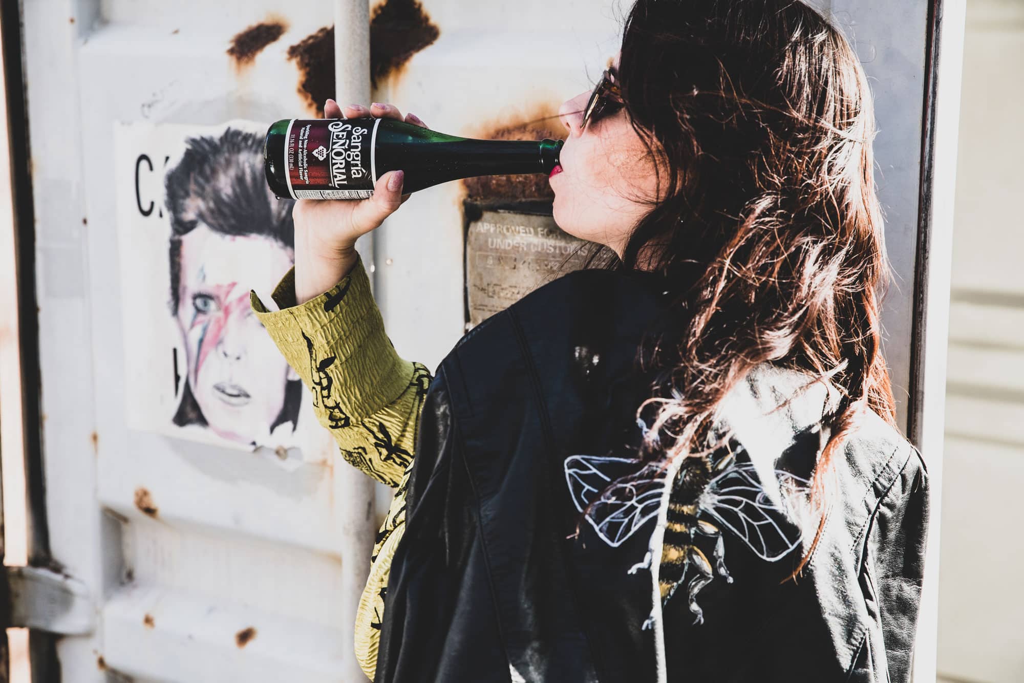 Lady taking a sip of a personal wine bottle.