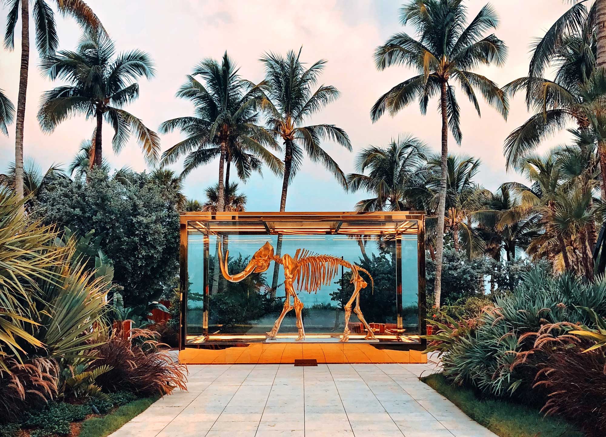 Miami Florida landscape showcasing a dinosaur in display around palm tress and bushes.