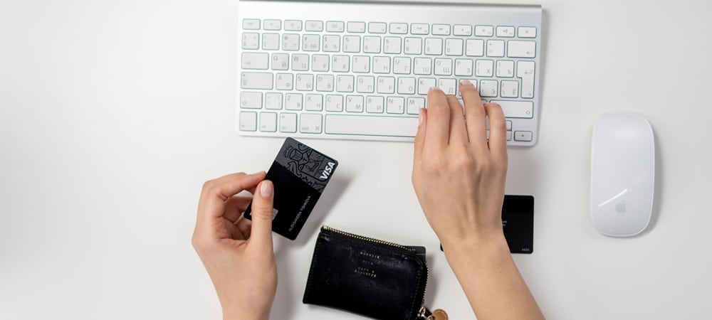 Woman shopping on Cyber Monday with credit card and wallet in hand.