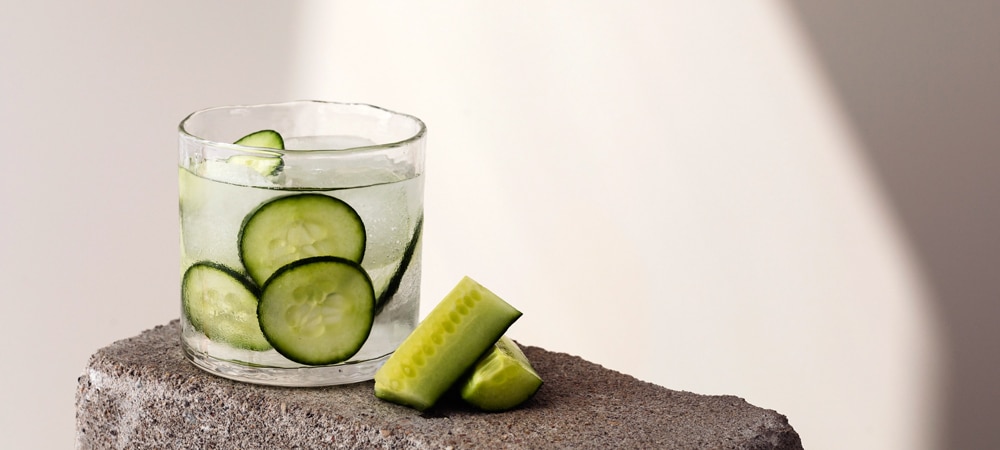 Gen Z consumer insights: A glass of a cold drink with cut cucumbers inside.