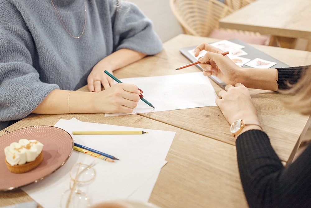 Two women sitting and exploring the graphic design needs of a brand.