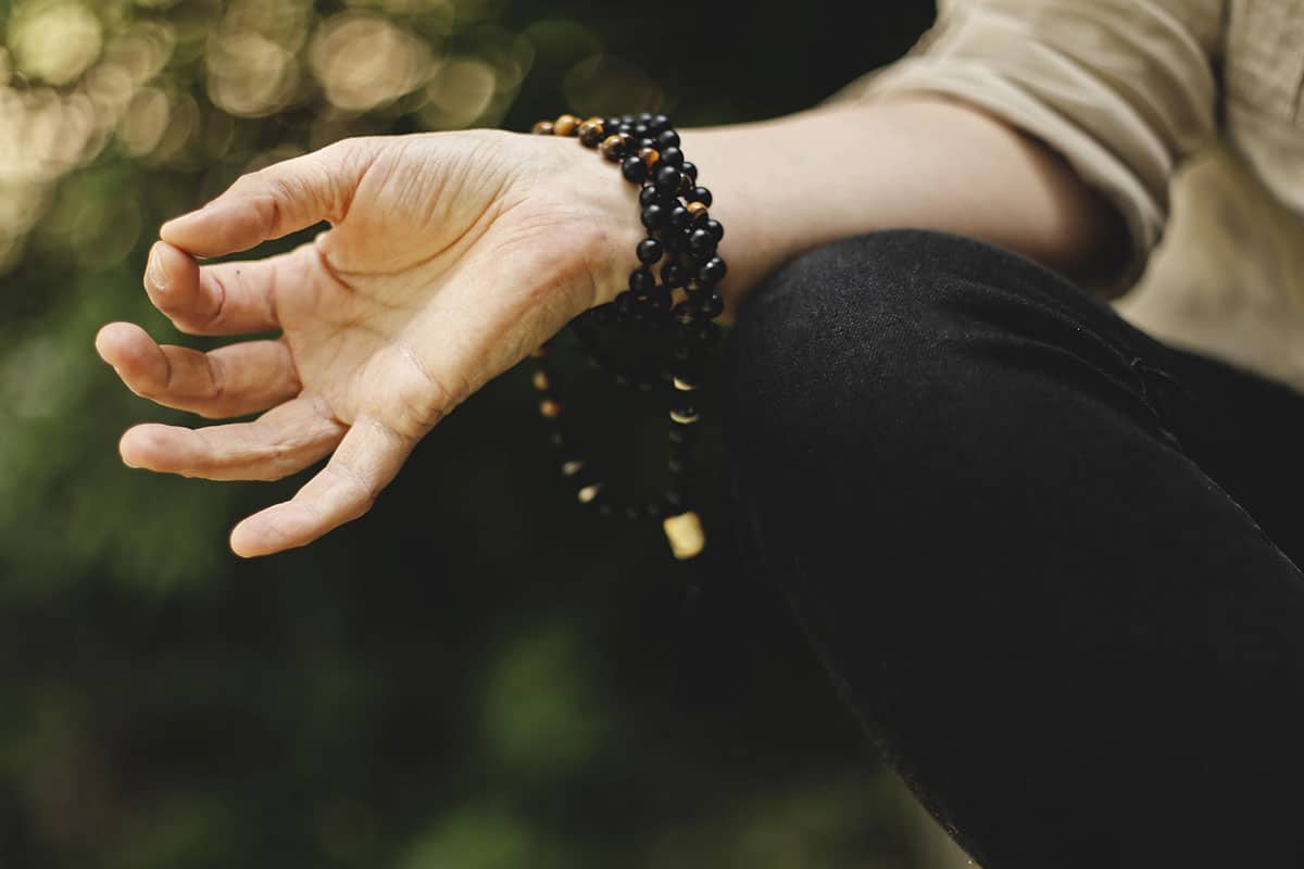 Woman meditating to stop feeling overwhelmed.