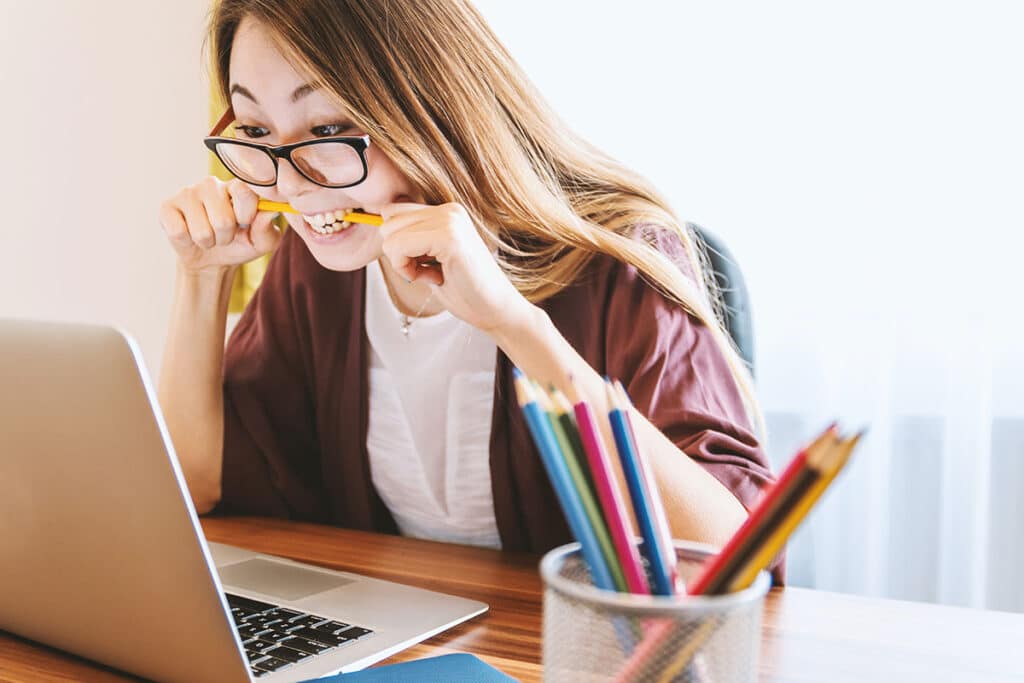 Woman biting her pencil and feeling stressed