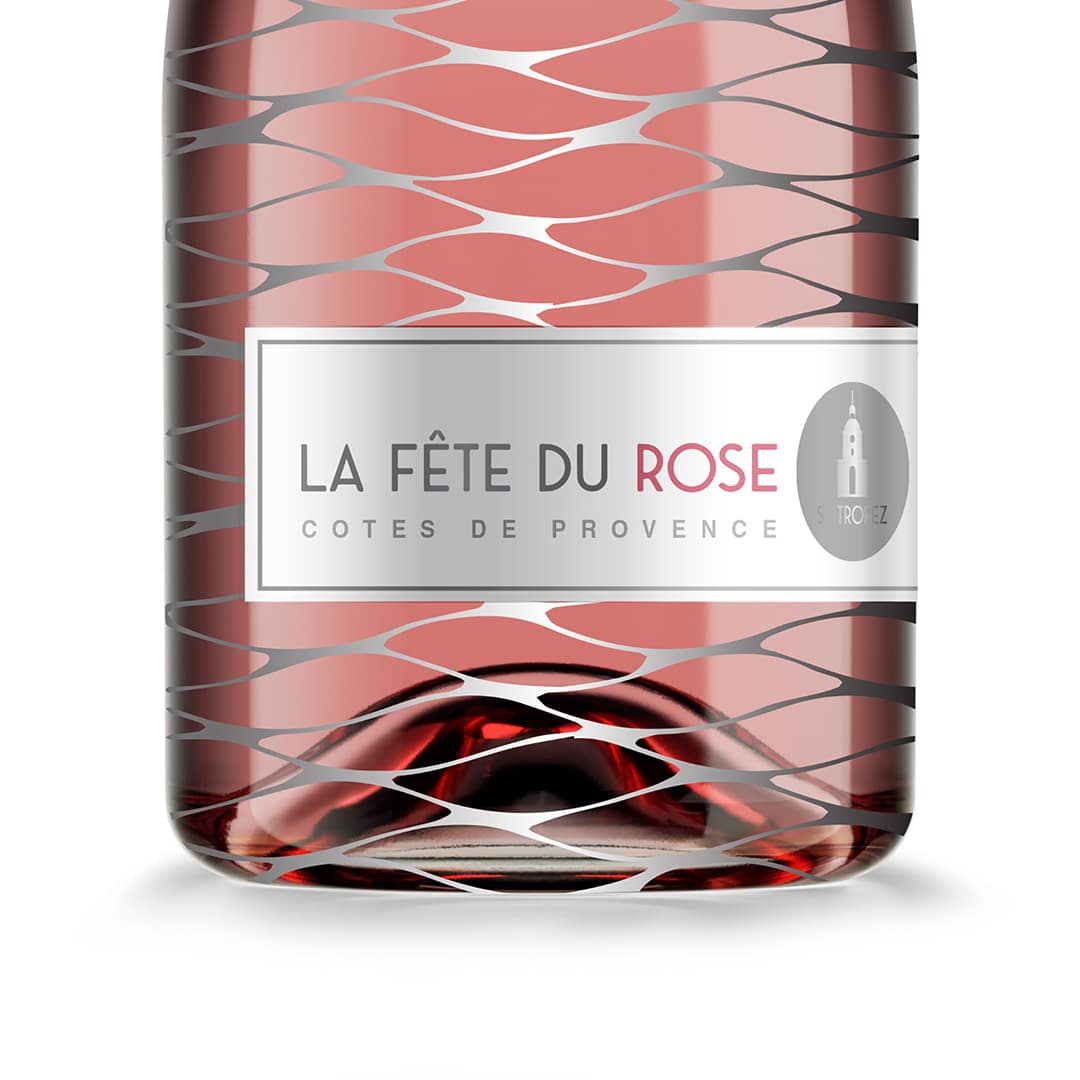 Wine Bottle Packaging Design: St. Tropez Rose wine bottle design close-up view showing label with St Tropez church steeple against wave-like silver mesh.