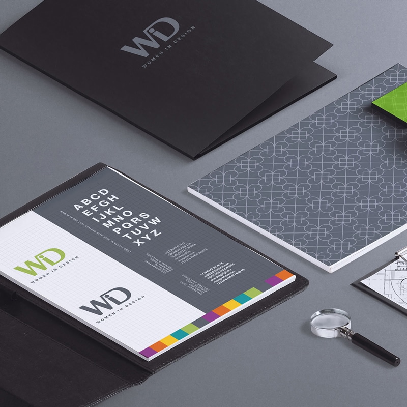 Women in Design stationary set showcasing business cards, folders, clipboard and other office utensils.