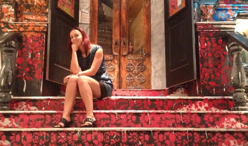 Woman entrepreneur sitting at top of stairs.