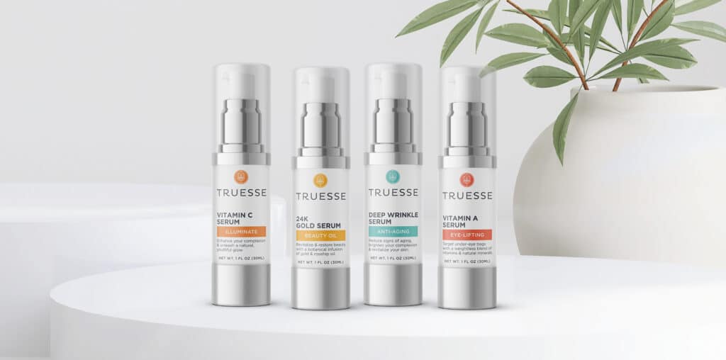 Launch a Beauty Brand: Truesse minimalist skincare packaging on a white platform with a potted plant in the background.