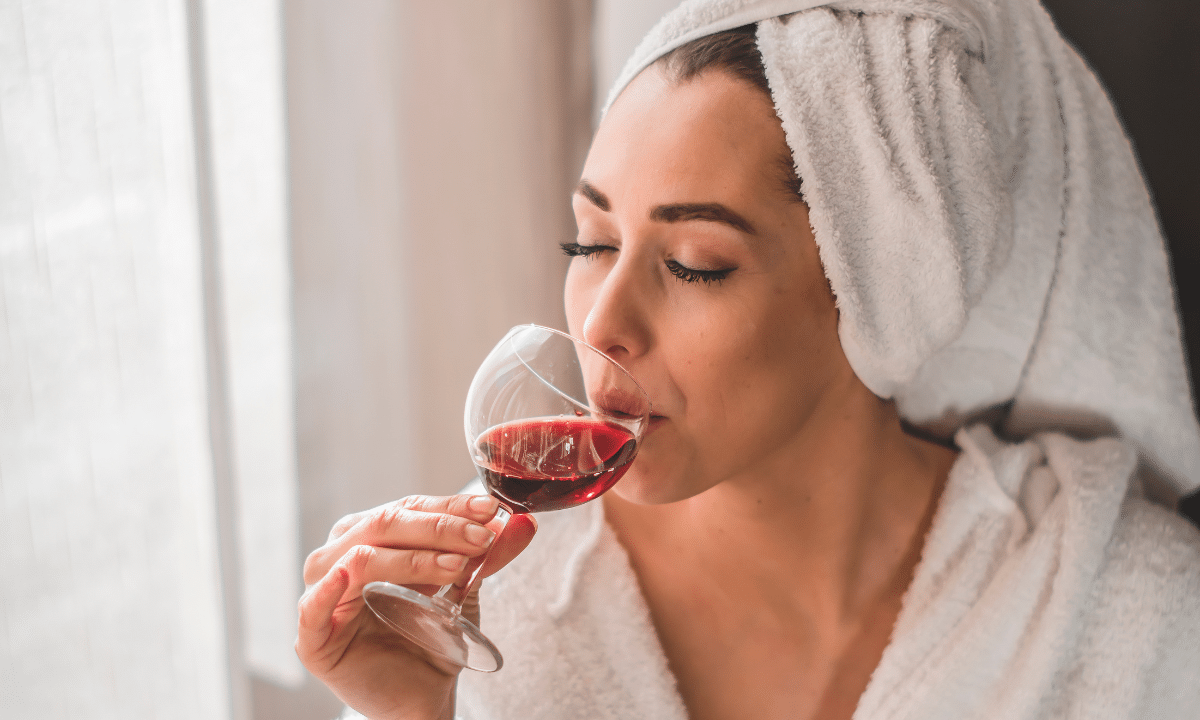 Alcohol branding for millennial woman as she's sipping wine in a robe.