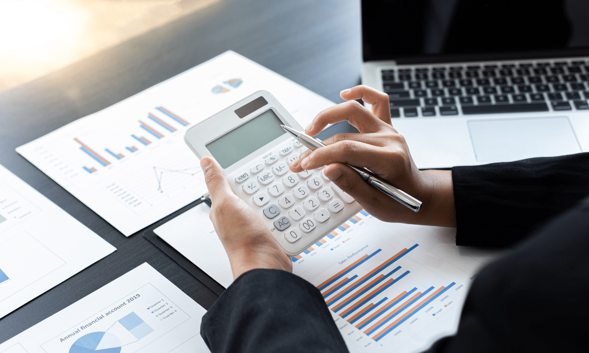 Woman calculating funds for investments with documents on desk.