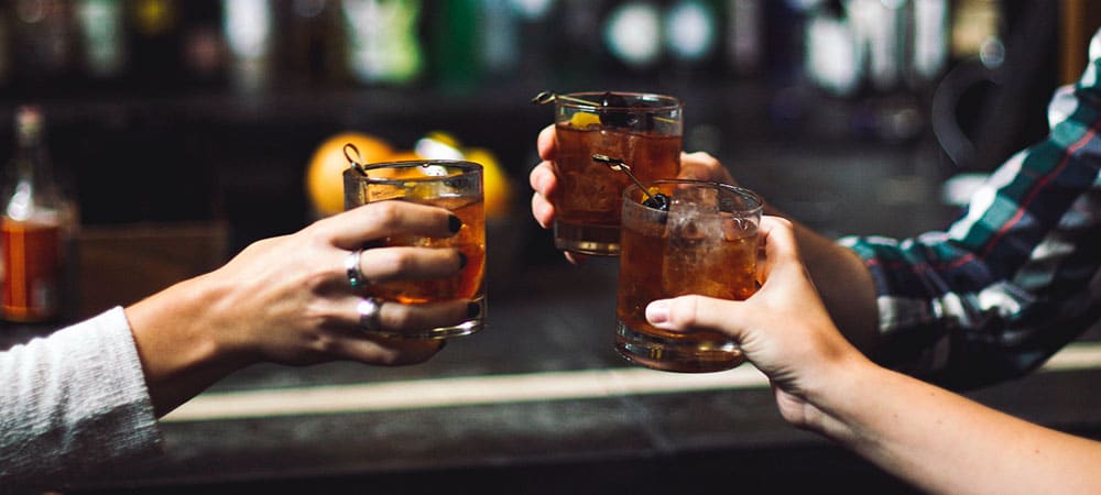 crafting your own alcohol brand with 3 people toasting their drinks